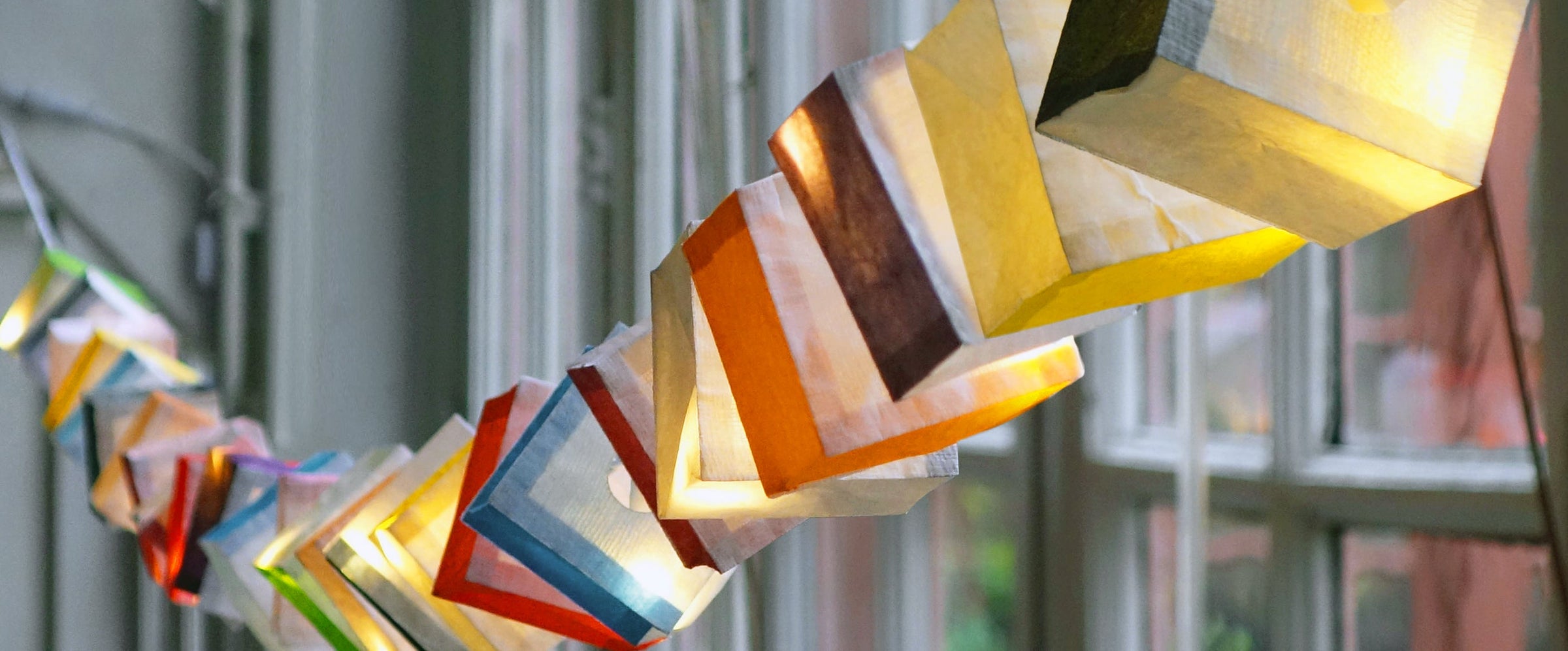Guirlande lumineuse en cubes de papier posée sur une corniche