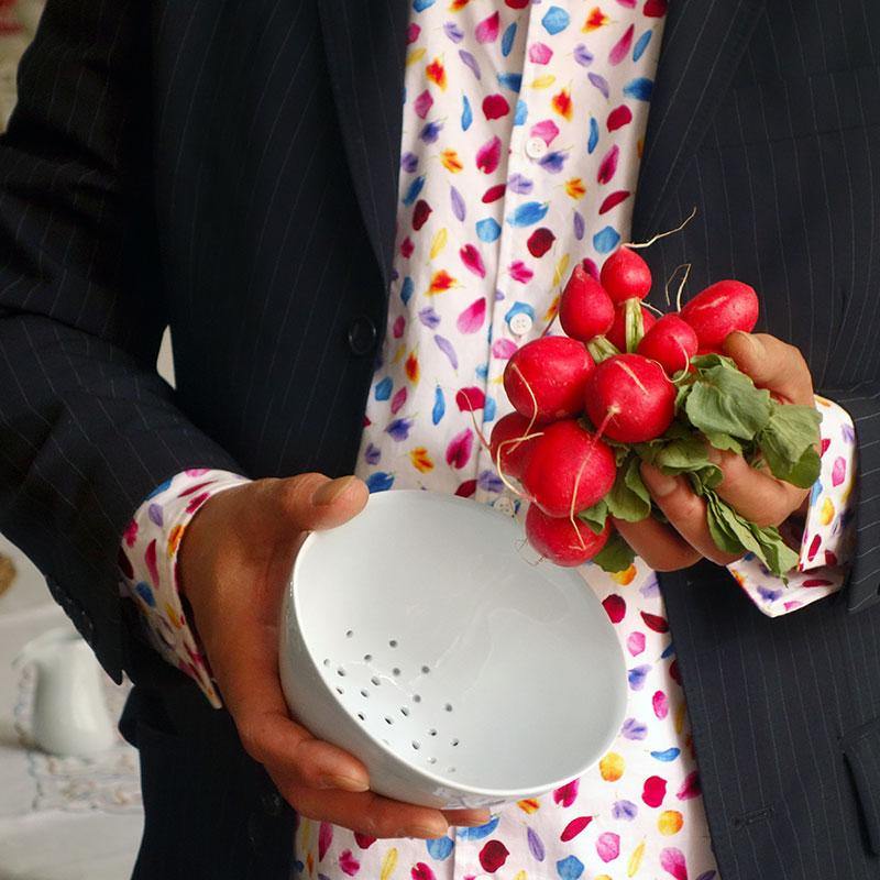 bol perforé en porcelaine blanche et bottes de radis tenus en main - tsé tsé