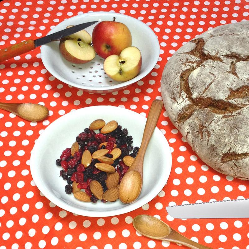 fruits secs dans une coupelle en porcelaine blanche sur uen nappe orange à pos blancs - tsé tsé