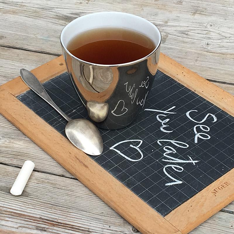 grande tasse à thé extérieur platine effet miroir posée sur une ardoise d'écolier - tsé tsé