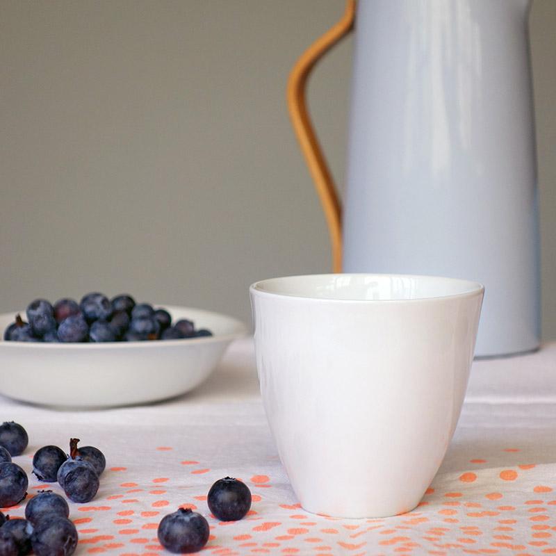 tasse à thé en porcelaine de forme irrégulière avec des myrtilles en arrière-plan - tsé tsé