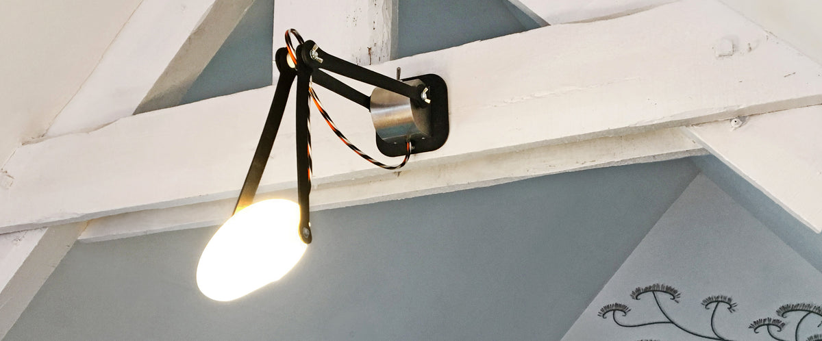 Lampe applique articulée accrochée sur une poutre