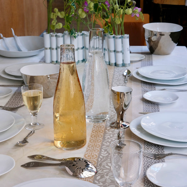 Table dressée avec carafes en verre et vaisselle en porcelaine