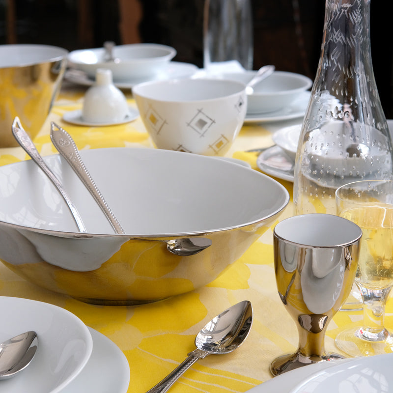 Tâble de fête dressée avec de la vaisselle en porcelaine et en platine