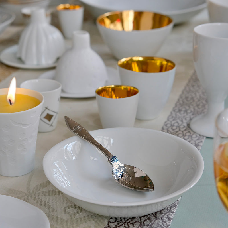 Gros plan sur une coupelle creuse en porcelaine, avec une petite cuillère dedans. Table de fête Tsé Tsé