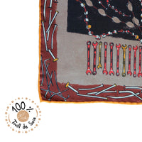Détail du foulard en twill de soie Tsé & Tsé 100%, zoomé sur un coin du tissu avec aperçu des motifs emblématiques et texture légère