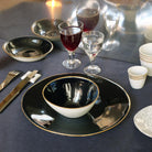 table dressée avec vaisselle bleu nuit et liseré doré et verres à pied de forme irrégulière - tsé tsé