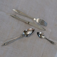 set de couverts de table en acier inoxydable avec manche poinçonné posés sur une nappe blanche - tsé tsé