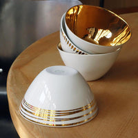 bols blancs et or en porcelaine empilés et retournés - tsé tsé
