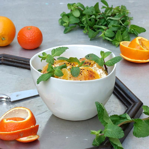 quartiers d'orange et feuilles de menthe dans un grand bol en poercelaine blanche - tsé tsé