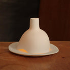 bougie allumée dans un photophore blanc en porcelaine mate - tsé tsé