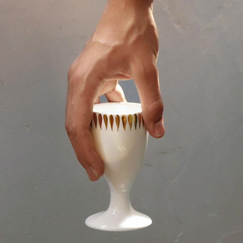 mazagran en porcelaine blanche et or tenu par une main - tsé tsé